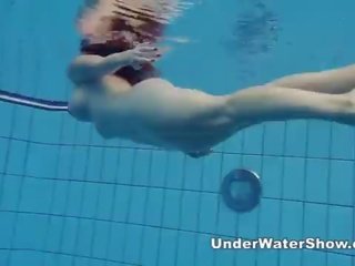 Redheaded enchantress svømming naken i den basseng